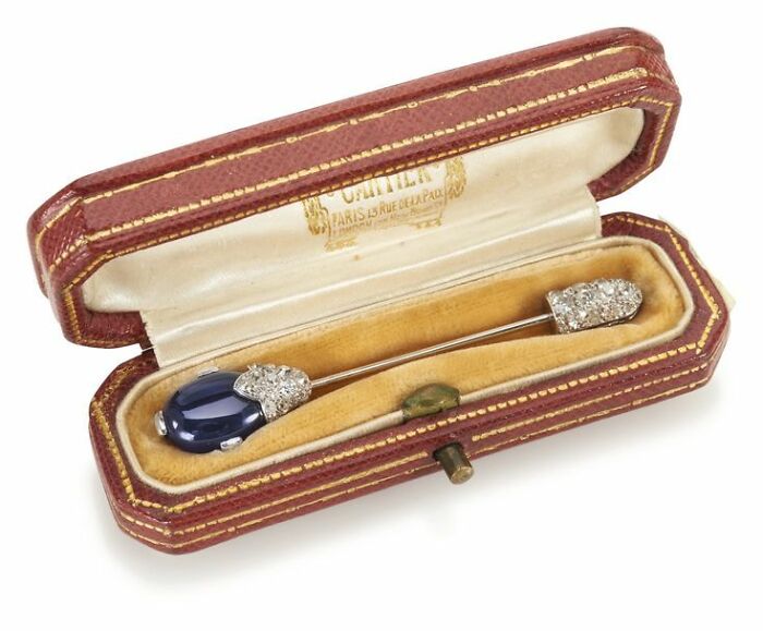 Antique jeweled stick pin in an open vintage case, showcasing old photos culture and everyday life in the past.