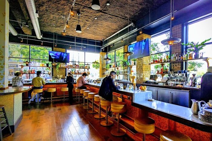 Upscale restaurant interior with patrons at the bar, related to Karen drunken rampage and tech executive exposure. Upscale restaurant interior with patrons at the bar, related to Karen drunken rampage and tech executive exposure.