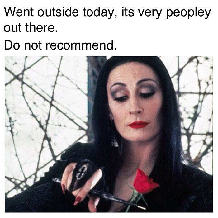 Woman dressed goth holding a rose with caption about people outside, featuring goth memes for anyone who doesn't fit in.