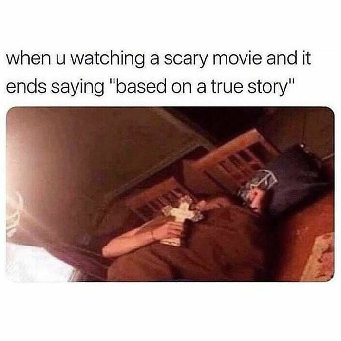 Person lying in bed holding a cross looking scared, representing a goth meme about scary movies and true stories.
