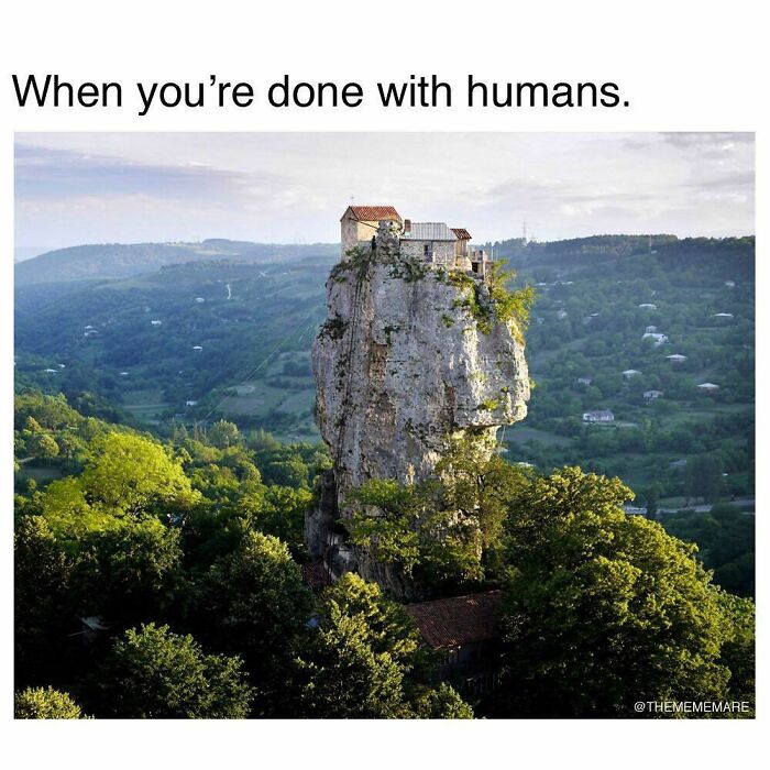 House perched atop a tall rock in a green landscape with caption about being done with humans, goth memes theme.