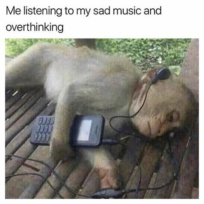 Monkey lying down with headphones and music player, overthinking while listening to sad music in a goth memes context