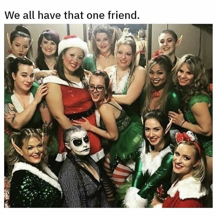 Group of friends dressed in festive and goth costumes, featuring a unique goth-themed individual standing out in the crowd.