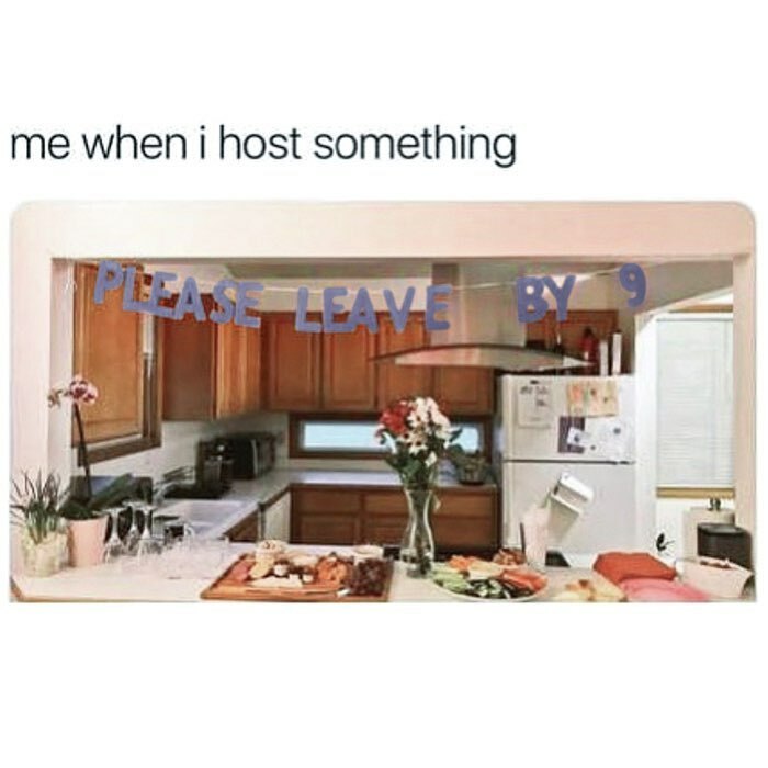Kitchen setup with food and a banner saying please leave by 9, capturing goth memes humor about hosting and fitting in.