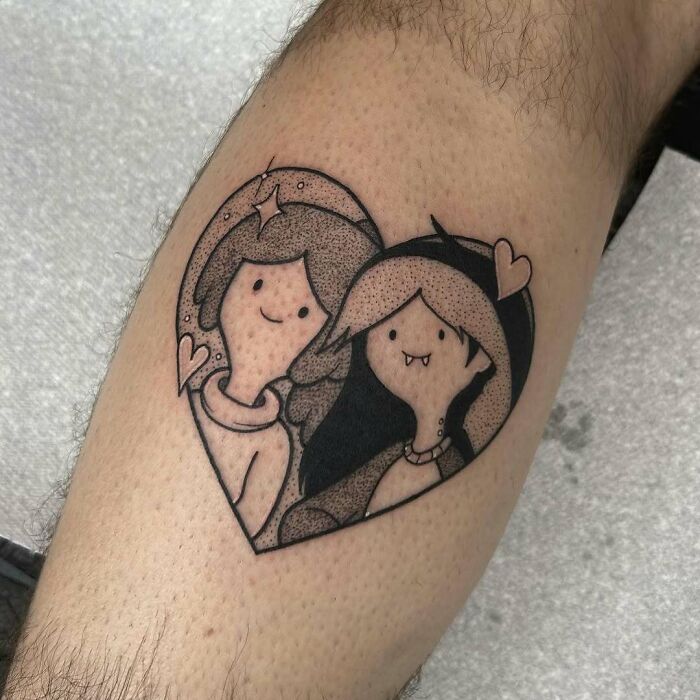 Heart-shaped tattoo of two cartoon characters on a leg, showcasing wholesome tattoos with meaningful ink art.