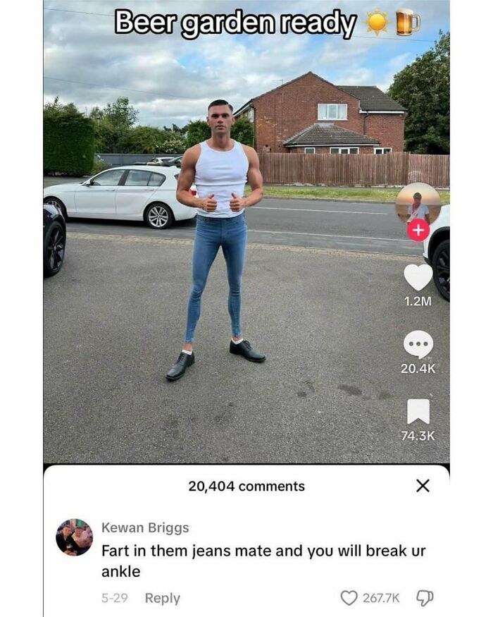 Man wearing extremely tight jeans and a white tank top, posing outdoors with a humorous meme comment about the jeans.