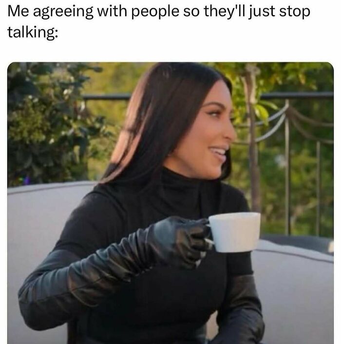 Woman in black outfit with gloves holding a white cup, smiling, meme about agreeing with people to stop talking, funny therapy humor.