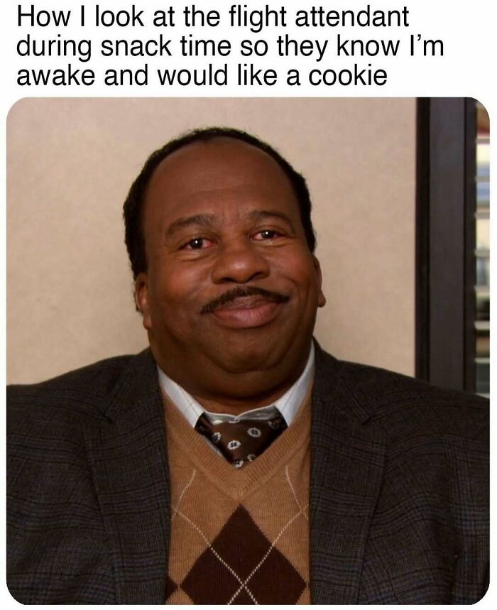 Man with a mustache smiling knowingly in a suit and argyle sweater, a hilarious meme for scrolling while waiting for therapy.