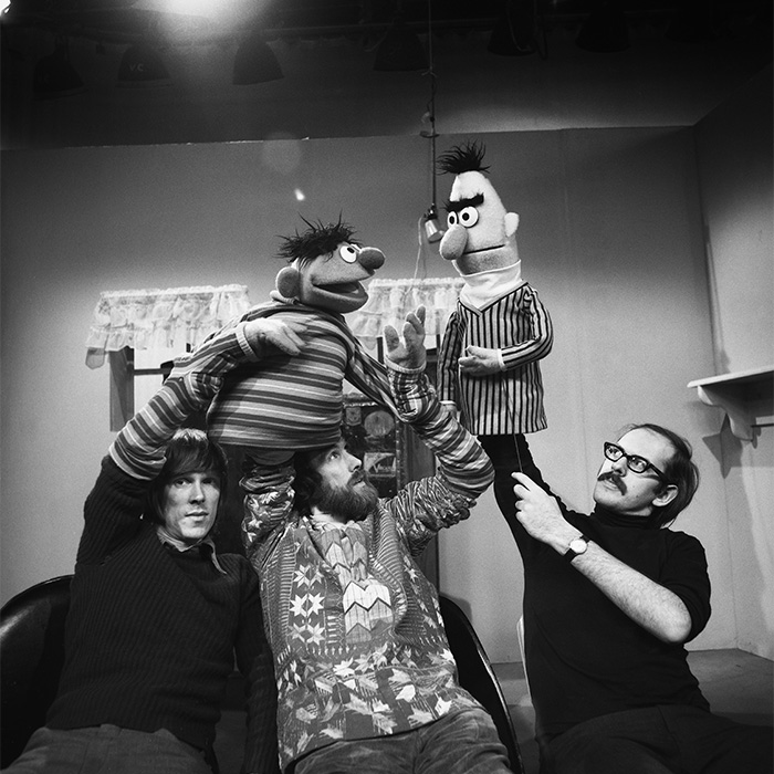 Behind-the-scenes black and white photo showing puppeteers operating rare pop culture characters Bert and Ernie.
