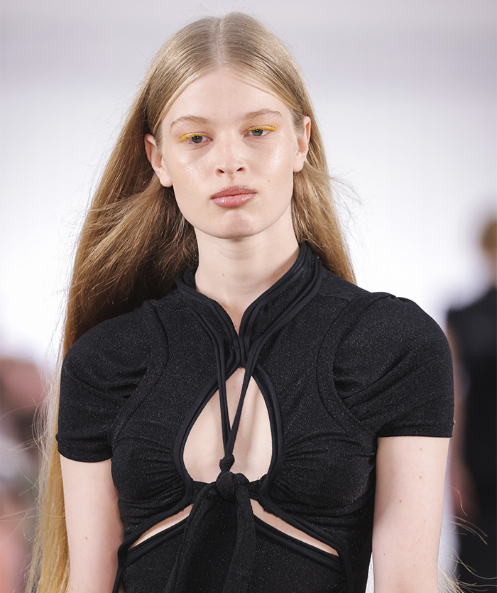 Young woman with long blonde hair wearing a black cut-out top, representing tragic mental illness awareness.