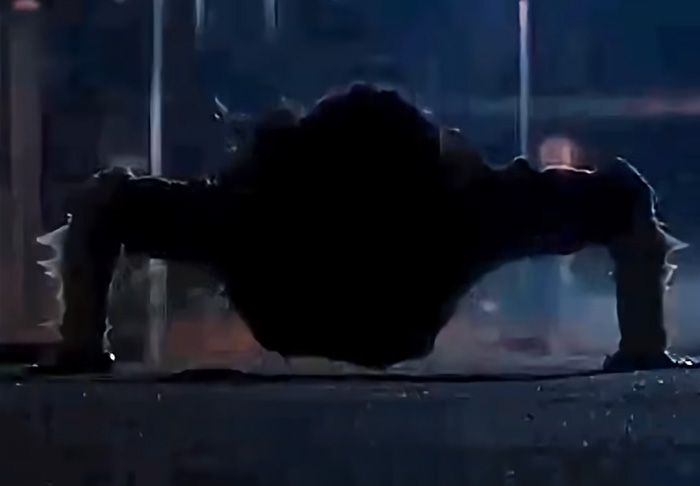 Silhouetted figure doing push-ups in a dark urban setting, evoking chilling urban legends and mysterious folklore.