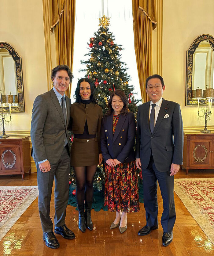 Justin Trudeau and Katy Perry with Japan's ex-PM posing in front of a decorated Christmas tree during a formal meeting. Justin Trudeau and Katy Perry with Japan's ex-PM posing in front of a decorated Christmas tree during a formal meeting.