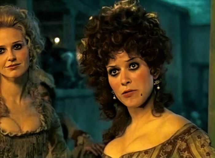 Two women dressed in vintage clothing in a dimly lit room, related to once famous regular job characters.