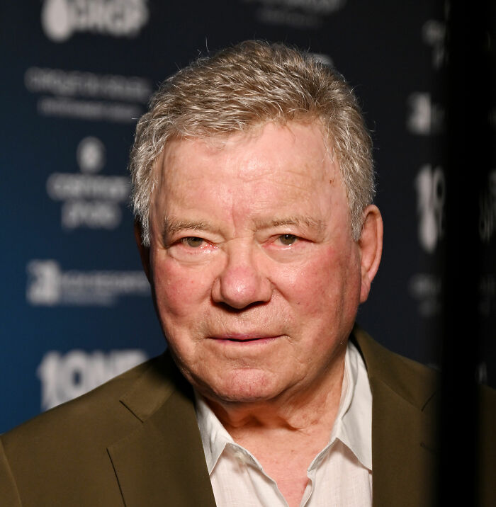 Older man in a brown jacket and white shirt at an event, related to banned stars from the Tonight Show by Johnny Carson.