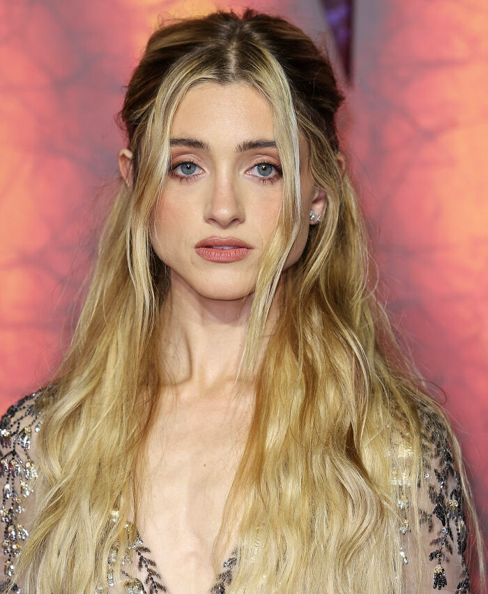 Stranger Things star Natalia Dyer with long blonde hair and neutral makeup, sparking fan comparisons to Ariana Grande.