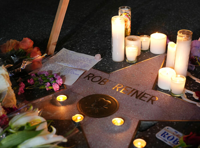 Rob Reiner&rsquo;s star on the Hollywood Walk of Fame surrounded by candles, flowers, and handwritten notes.