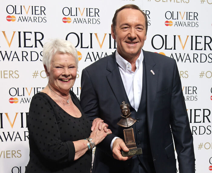 Dame Judi Dench at Olivier Awards with actor holding award, related to Harvey Weinstein defense sparking outrage. Dame Judi Dench at Olivier Awards with actor holding award, related to Harvey Weinstein defense sparking outrage.