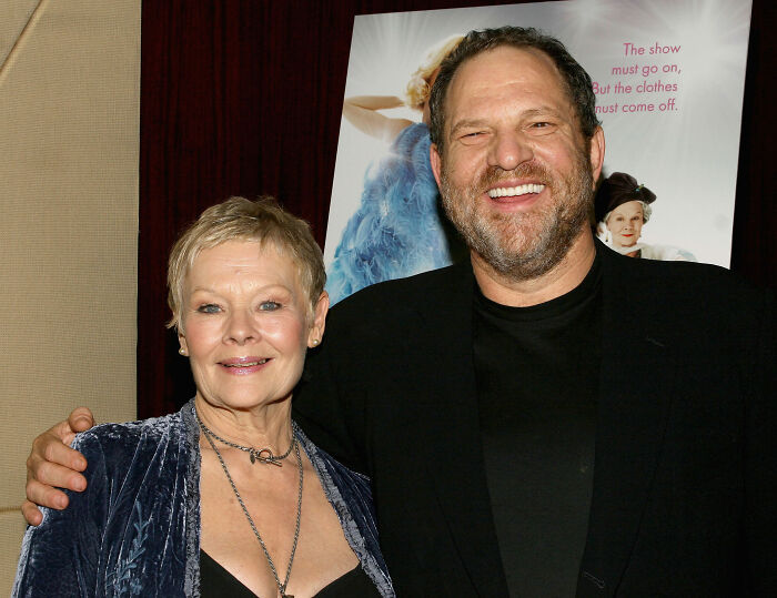 Dame Judi Dench posing with Harvey Weinstein at an event, sparking outrage over her defense statements. Dame Judi Dench posing with Harvey Weinstein at an event, sparking outrage over her defense statements.