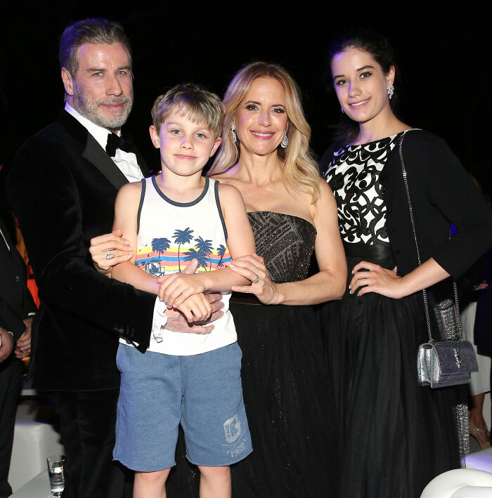 John Travolta with family at an event, highlighting Riley Keough as biological mother of son Ben in court documents.