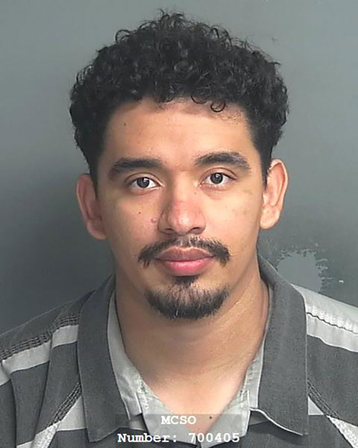 Mugshot of a man with curly hair and a goatee, related to heroic Texas dad rescuing kidnapped daughter in the woods.