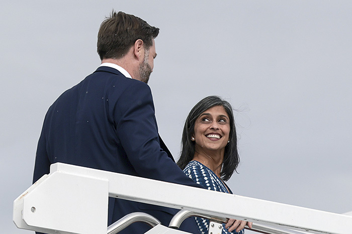 Usha Vance smiling at JD Vance while ascending stairs, highlighting public speculation about their marriage.