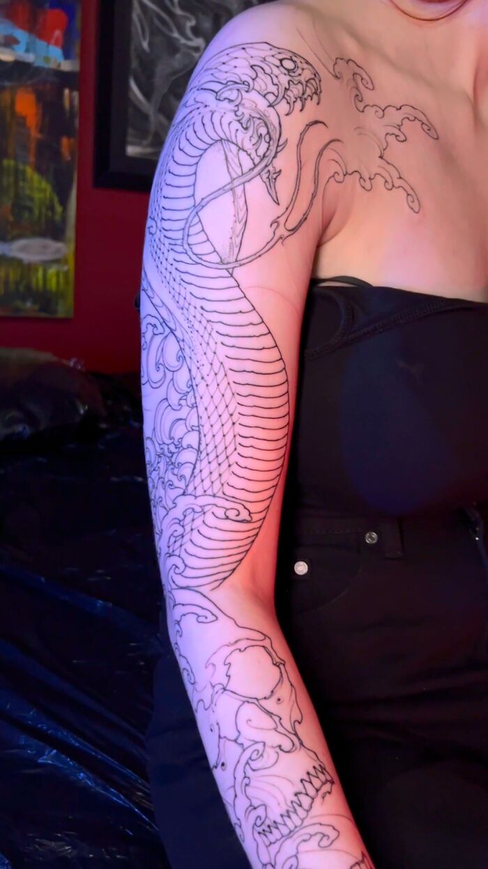 Arm tattoo outline of a snake with scales and flowing waves, showcasing detailed pet tribute tattoo art.