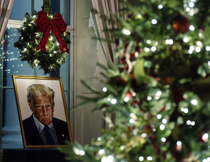 Framed pixel art portrait of Donald Trump with a Christmas wreath featuring a red bow in a festive setting.
