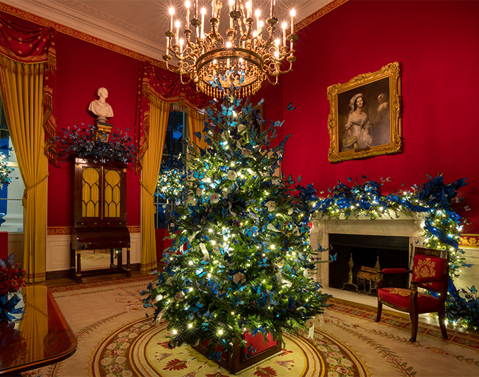 Christmas tree decorated in a lavish room, highlighting Melania Trump&rsquo;s new Christmas ornament controversy and its high cost.