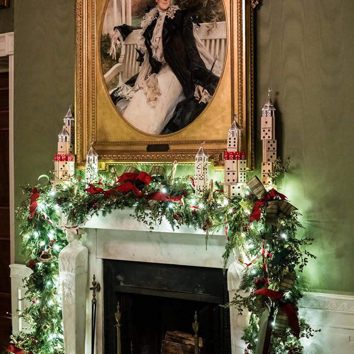 Christmas mantel decorated with lights and red bows featuring Melania Trump&rsquo;s new Christmas ornament known for its high cost.