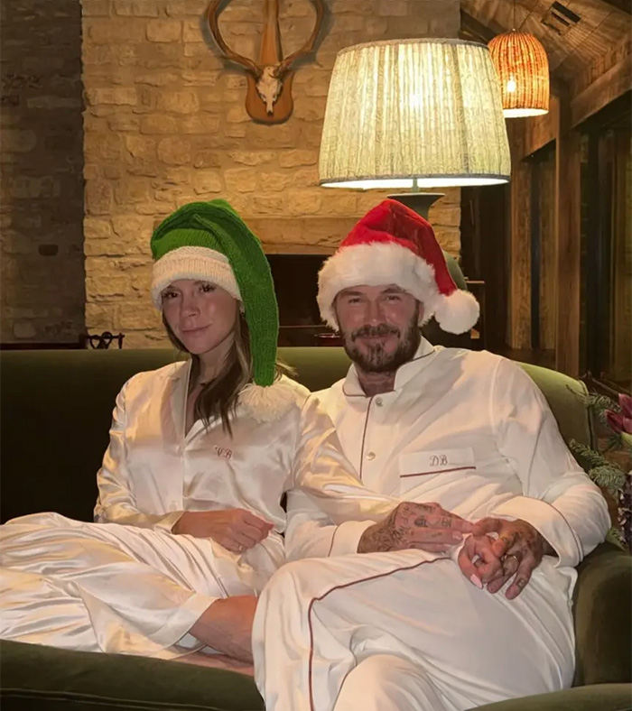 Brooklyn&rsquo;s wife Nicola Peltz and Victoria wearing festive hats, sitting closely on a couch in holiday pajamas.