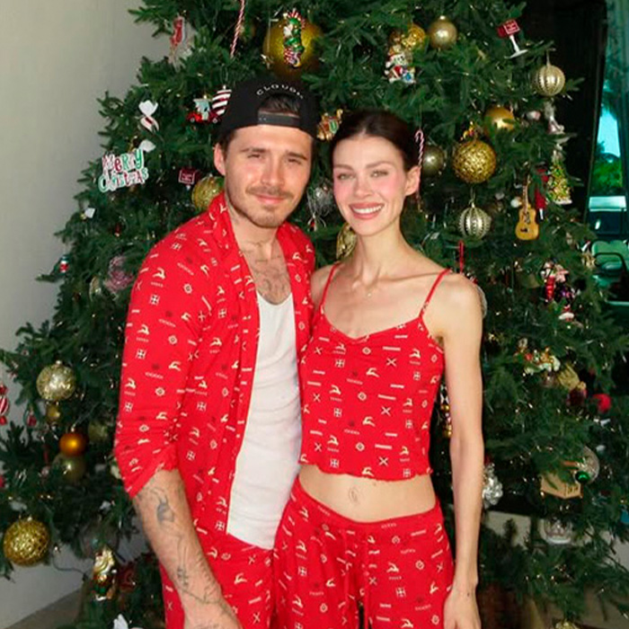 Brooklyn&rsquo;s wife Nicola Peltz and Victoria posing in matching red pajamas by a Christmas tree.