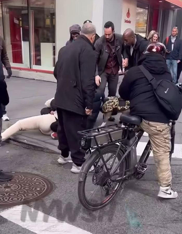 Crowd gathers on busy Manhattan street as pit bull attacks toddler, refusing to release grip during incident.