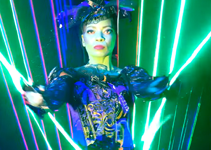 Performer in a Wizard Of Oz stage show wearing a dark costume with green laser lights illuminating the background.