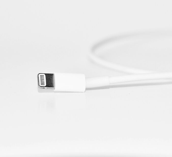 Close-up of a white charging cable on a plain surface, illustrating calm versus stress in everyday tech scenarios.