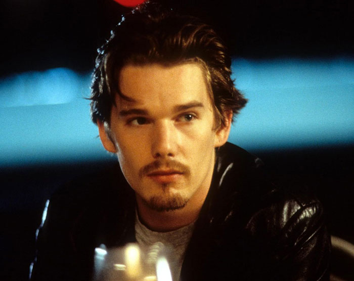 Ethan Hawke looking thoughtful in a dark setting, his pairing with Sydney Sweeney sparking online firestorm.