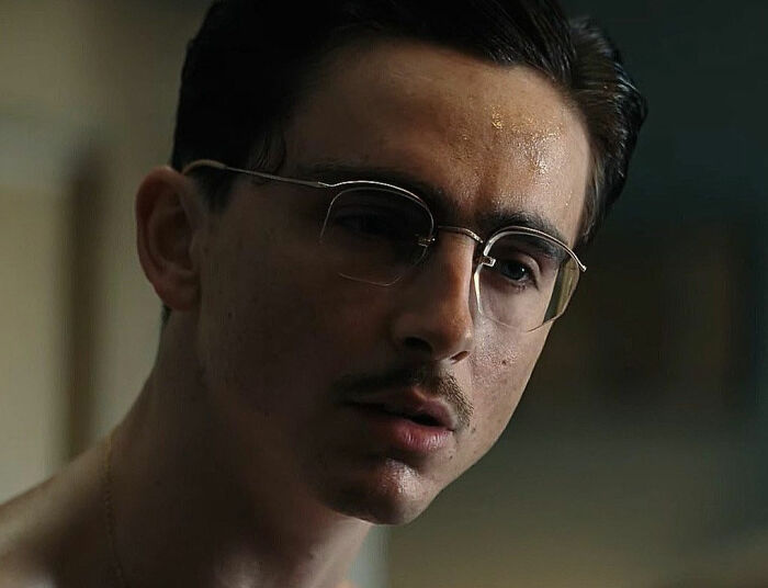 Close-up of Timoth&eacute;e Chalamet wearing glasses, showcasing his red carpet look with an unusual detail noticed by fans.