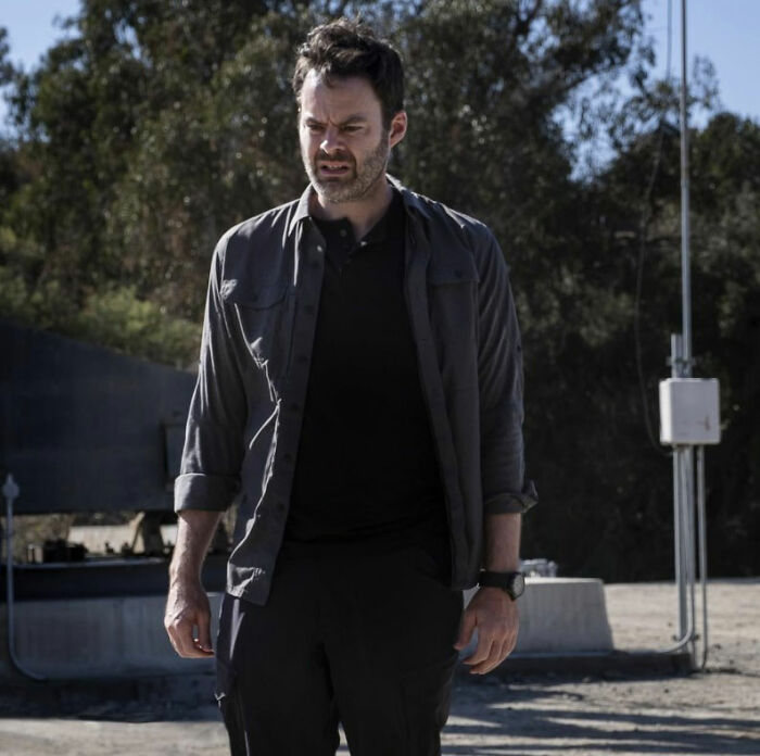Bill Hader outdoors in casual dark clothing, appearing tense during a moment at a social gathering.