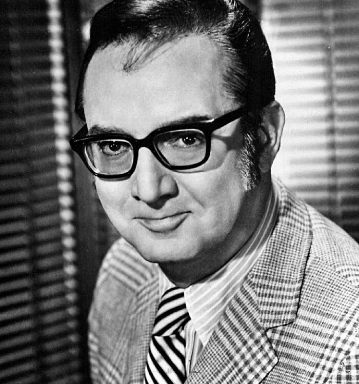 Black and white portrait of a man in glasses and a plaid suit, related to banned stars from the Tonight Show Johnny Carson.
