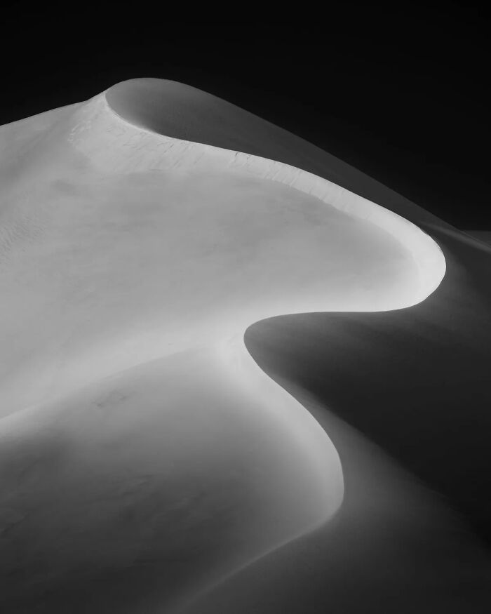 Black and white nature photography of smooth sand dunes with soft light and shadow, showcasing best nature photography.