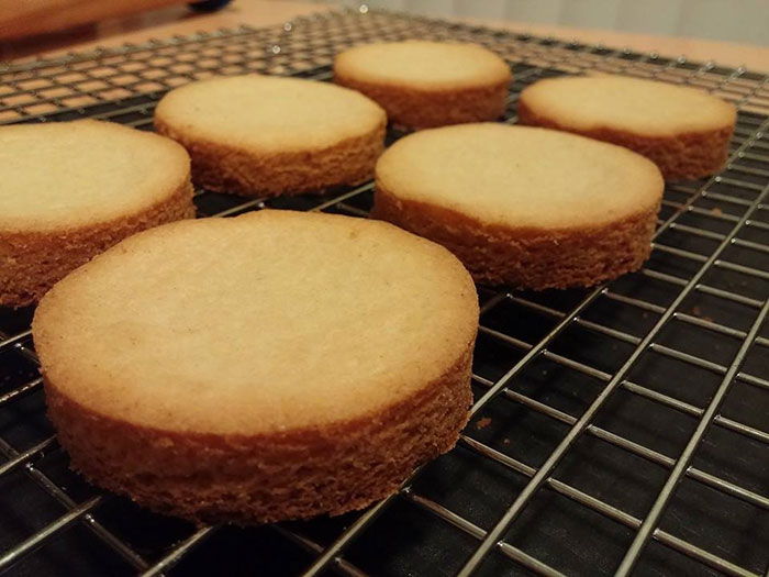 Freshly baked round pastries cooling on a wire rack, highlighting a boyfriend's passion for pastries in a relationship.
