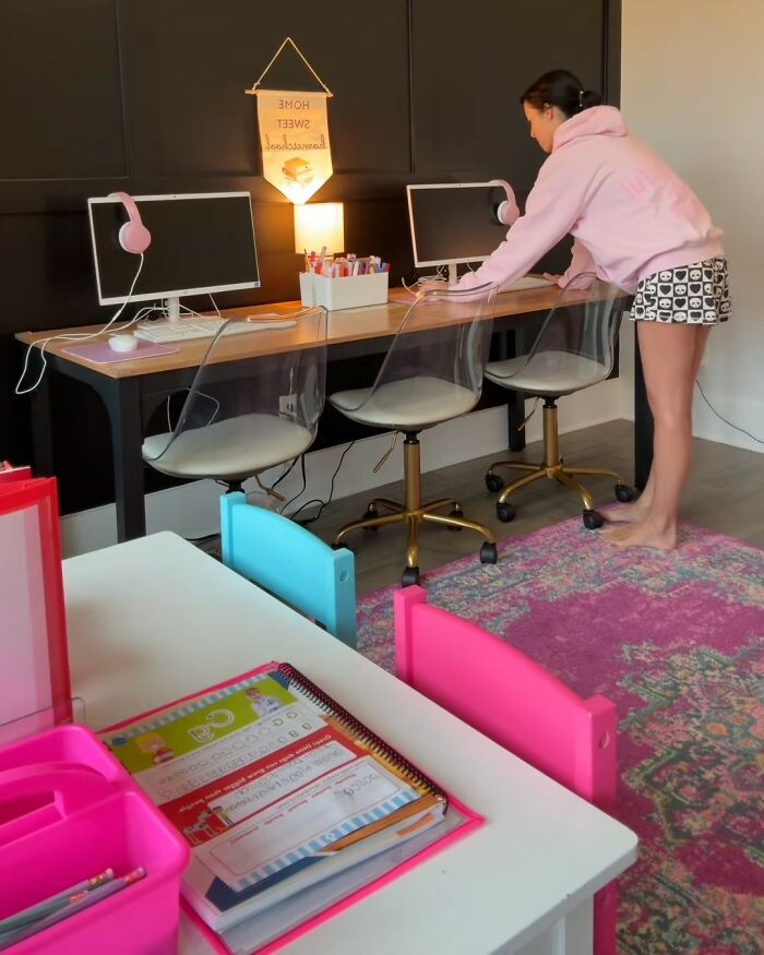Child setting up a homeschool workspace with computers and school supplies in a brightly colored learning area.