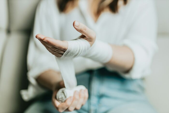 Person wrapping their hands with bandages, symbolizing chefs who stopped cooking professionally due to injury or strain.