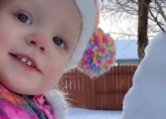 Young girl bundled in winter clothes outside near a snow figure, relating to mom's chilling Google searches and slaying case.