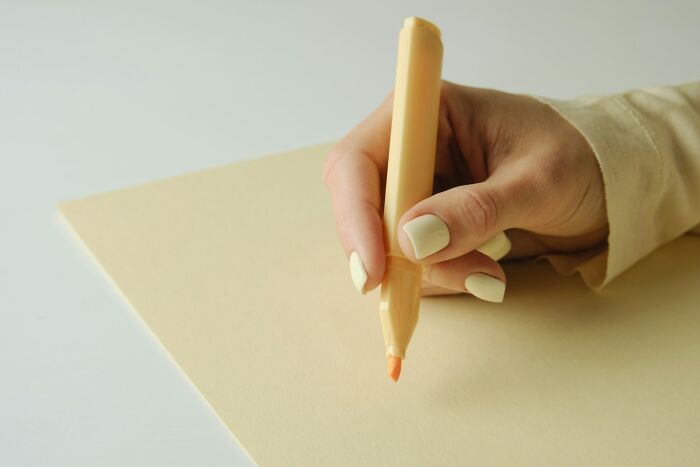 Close-up of a hand holding a highlighter over paper, illustrating everyday things people did wrong unknowingly.