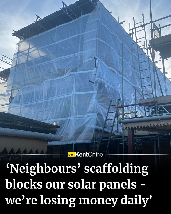 Scaffolding covered building blocking solar panels on roof causing daily financial loss in local neighborhood.