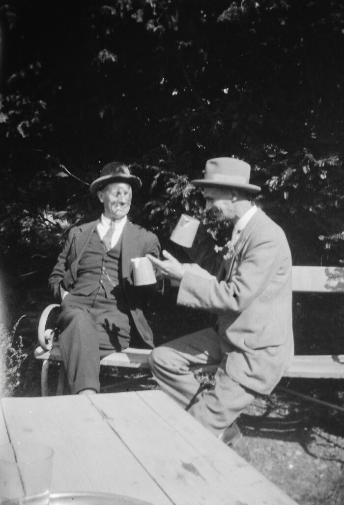 Two men in vintage suits and hats, enjoying drinks outdoors, symbolizing incredible minds without a degree.