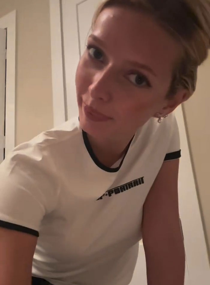 Apple Martin leaning forward indoors, wearing a white ringer t-shirt, linked to Self-Portrait modeling campaign video.