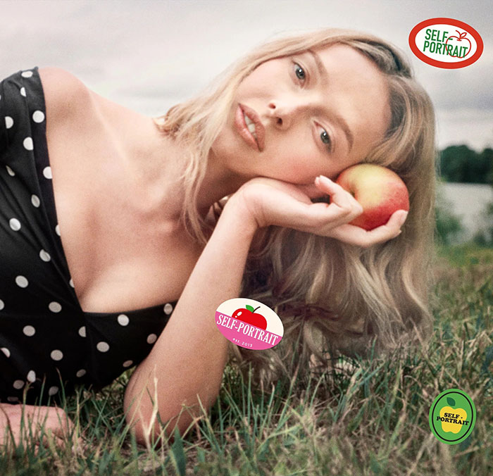 Apple Martin poses outdoors holding an apple, promoting Self-Portrait modeling campaign in a polka dot dress.