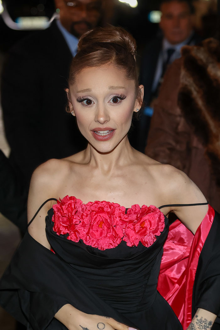 Ariana Grande attending an event wearing a black dress with red floral detailing, addressing body-shaming concerns. Ariana Grande attending an event wearing a black dress with red floral detailing, addressing body-shaming concerns.