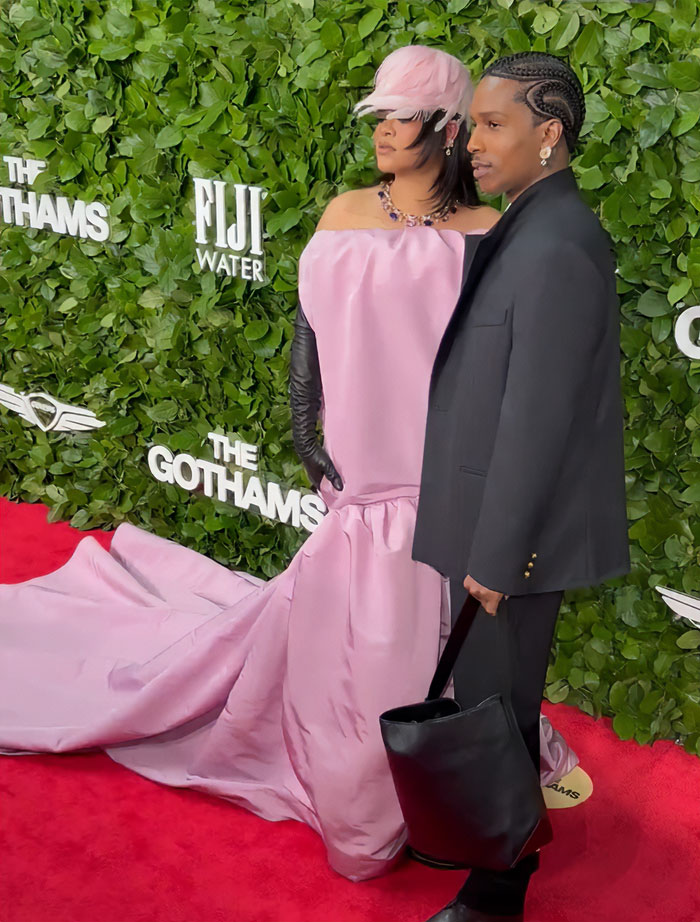 Rihanna on the red carpet in a pink gown with a large black bag, sparking wild reactions about the diaper bag.